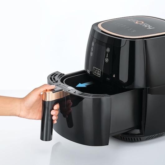 BLACKDECKER AF5539 air fryer side view, hand holding black drawer handle with gold accent