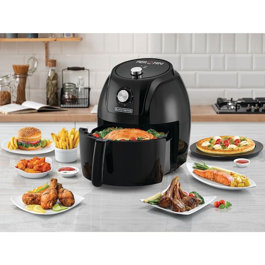 BLACKDECKER AF575 air fryer front view with assorted cooked dishes including burger, fries, chicken and pizza.