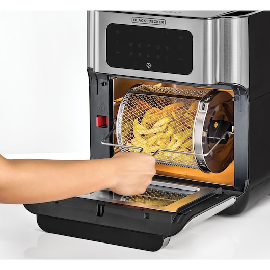 BLACK+DECKER AOF100 air fryer with a mesh drum basket filled with fries, front angle, open door.