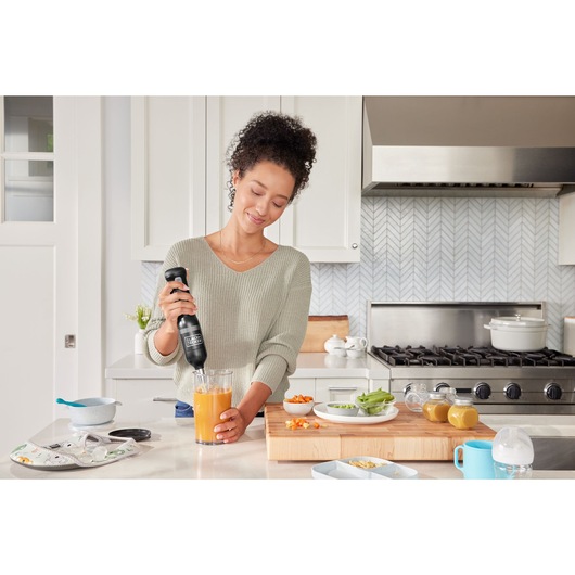 BLACKDECKER BCKM1012KB hand blender mixing orange liquid in kitchen setting.