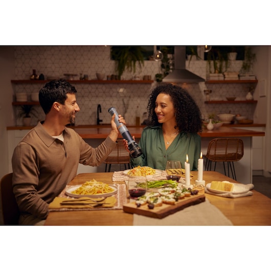 BLACKDECKER pepper grinder BCKM101SPFF used at a dinner table with pasta and candles, lifestyle setting.