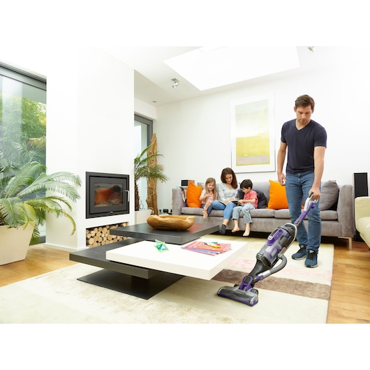 BLACKDECKER CUA525BHP cordless vacuum cleaner in use in modern living room setting, visible on floor.