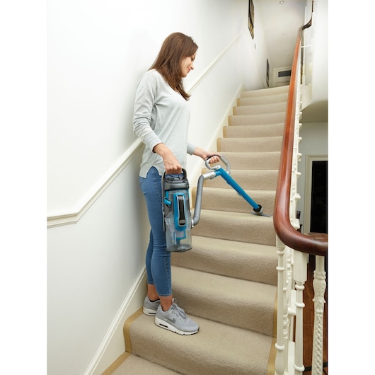 BLACKDECKER CUA525BH vacuum cleaner used on carpeted stairs, showing portable design.