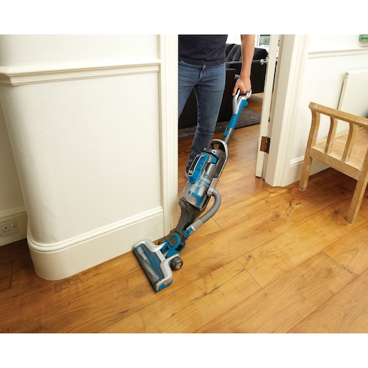 BLACKDECKER CUA525BH upright vacuum cleaner on wood floor in home setting, blue and gray design.