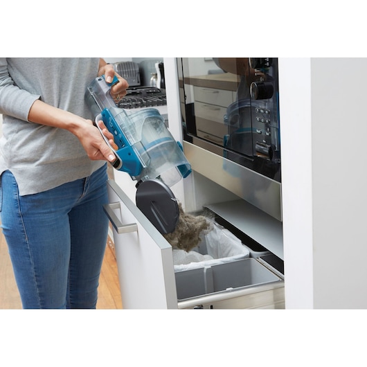 Photo of BLACKDECKER CUA525BH vacuum cleaner bin being emptied into kitchen trash drawer.