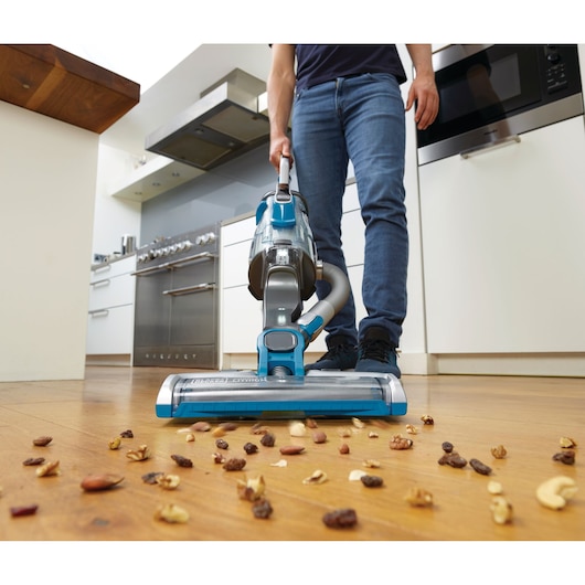 BLACKDECKER CUA525BH cordless vacuum cleaning nuts on kitchen floor, front angle.