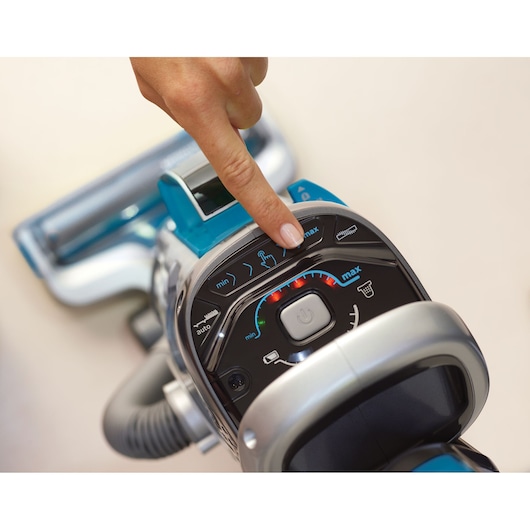 BLACKDECKER CUA525BH vacuum cleaner control panel close-up with finger pressing power button.