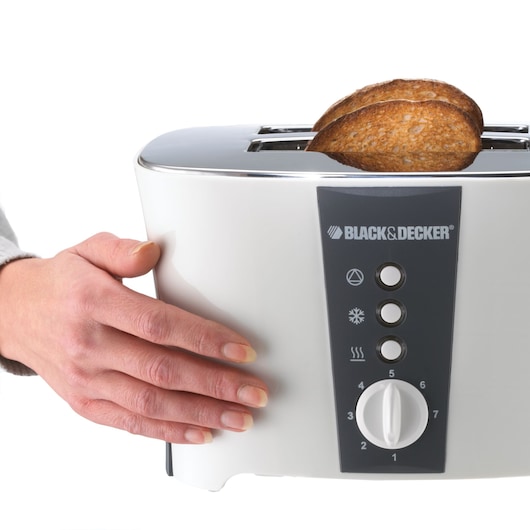 BLACKDECKER toaster ET122 with toast and hand, front angle on white background.