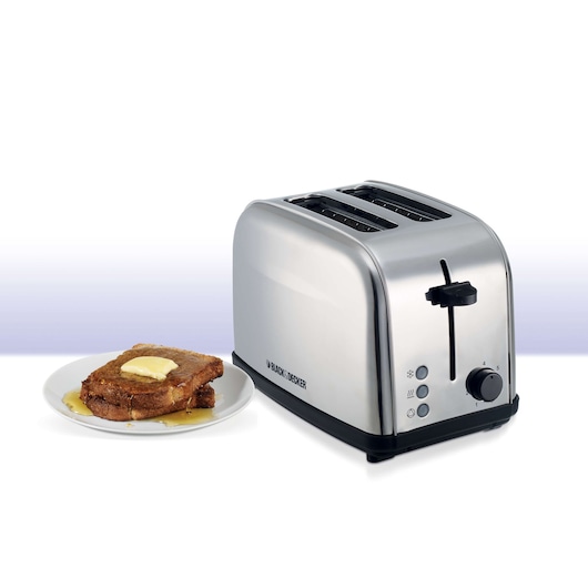 A stainless steel BLACK+DECKER 2-slice toaster with a plate of French toast topped with butter and syrup beside it.