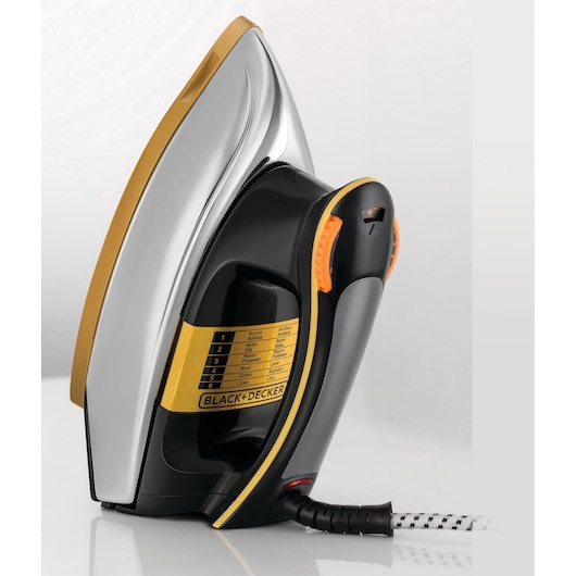 A close-up view of a BLACK+DECKER F550 electric iron featuring a gold and silver metal soleplate, black and yellow plastic casing, an orange temperature control dial, and a fabric settings guide on the side, with a black and white power cord visible.