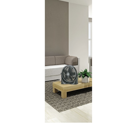 BLACK+DECKER FB1620 portable fan on wooden table in modern living room, next to a potted plant.
