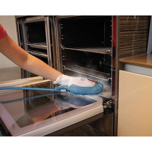 BLACKDECKER FSH10SM steam cleaning glove used on an oven door, close-up view.
