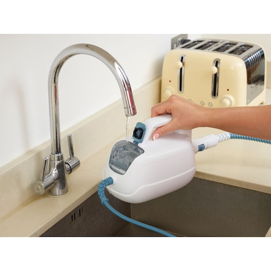 BLACK+DECKER FSH10SM handheld steam cleaner with hose being filled with water from a sink faucet, side view.