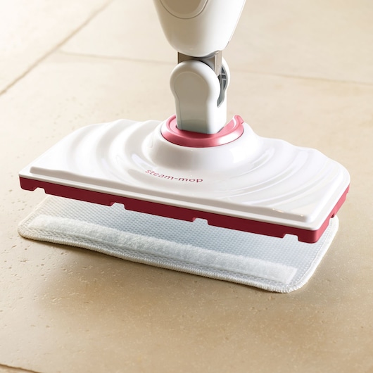 BLACKDECKER FSM1605R steam mop with white and pink base cleaning tile floor, side angle.