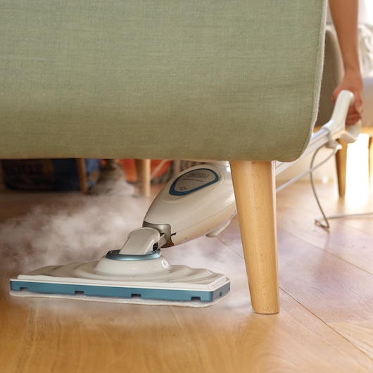 BLACKDECKER FSM1605 steam mop cleaning wood floor under sofa, close-up view.