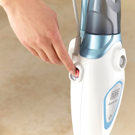 Photo of BLACKDECKER FSM1605 steam mop being powered on with close-up of finger pressing red button.