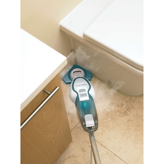 BLACKDECKER FSM1616 steam mop cleaning bathroom floor near toilet, emitting steam, top-down angle.