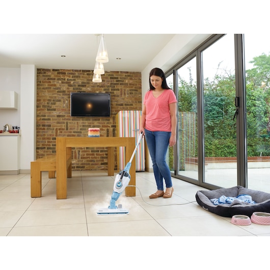 BLACKDECKER FSMH13151SM steam mop cleaning tiled floor in modern dining area, person holding handle.