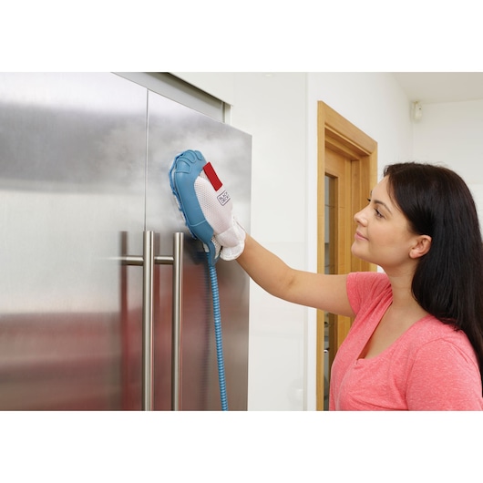 BLACK+DECKER FSMH13151SM steam cleaning mitt in use, cleaning stainless steel fridge door in modern kitchen.
