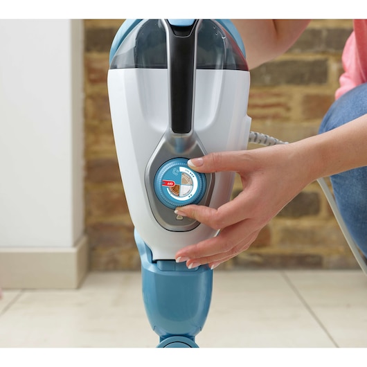 BLACK+DECKER FSMH13151SM steam mop close-up, hand adjusting blue control dial, indoors.