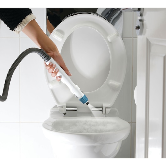 BLACKDECKER FSMH13151SM steam cleaner nozzle cleaning a white toilet bowl with steam.