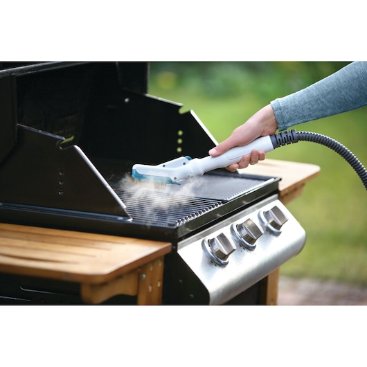 BLACKDECKER FSMH13151SM steam cleaner cleaning grill grate outdoors, product shown in use