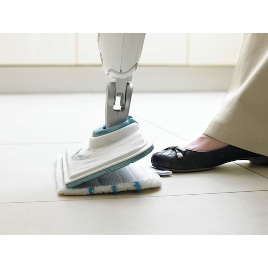 BLACKDECKER FSMP20 steam mop pad being attached to mop head on tiled floor, side angle.