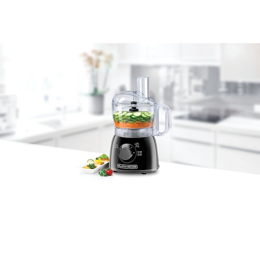 BLACKDECKER FX400 food processor in black on kitchen counter with sliced vegetables in bowl.