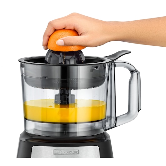 Photo of BLACKDECKER FX650 citrus juicer with transparent jug, squeezing orange half, side angle, white background.