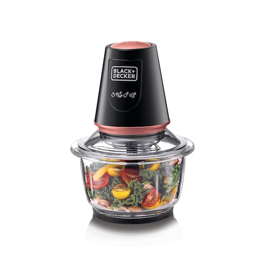 A BLACK+DECKER electric food chopper with a black and copper colored top and a clear glass bowl containing chopped vegetables including tomatoes and leafy greens.