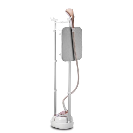A BLACK+DECKER upright garment steamer with a rose gold steam nozzle, a padded ironing board, and adjustable metal poles. The steamer is designed for vertical steaming and includes a hose connected to the base. Product SKU GSTD2050.