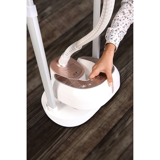 Photo of BLACKDECKER GSTD2050 garment steamer base with control panel, user adjusting settings, white and rose gold.