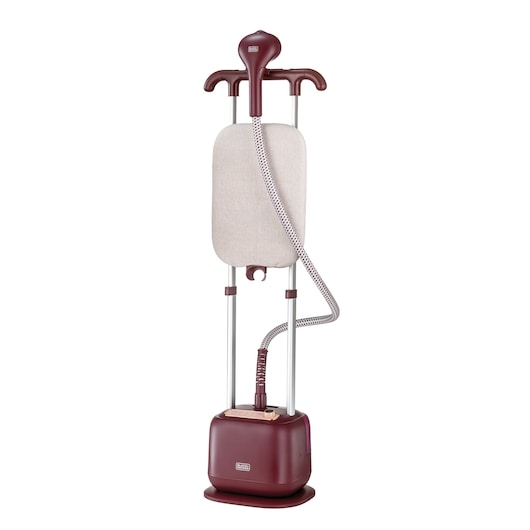 A vertical garment steamer in maroon color with a built-in ironing board and flexible steam hose, designed for steaming clothes. The product is branded BLACK+DECKER.