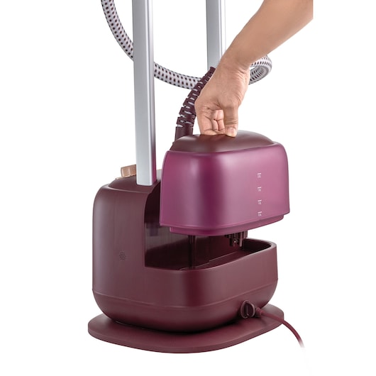 Photo of BLACK+DECKER GSTD2450 upright garment steamer in maroon, hand removing water tank, side angle.