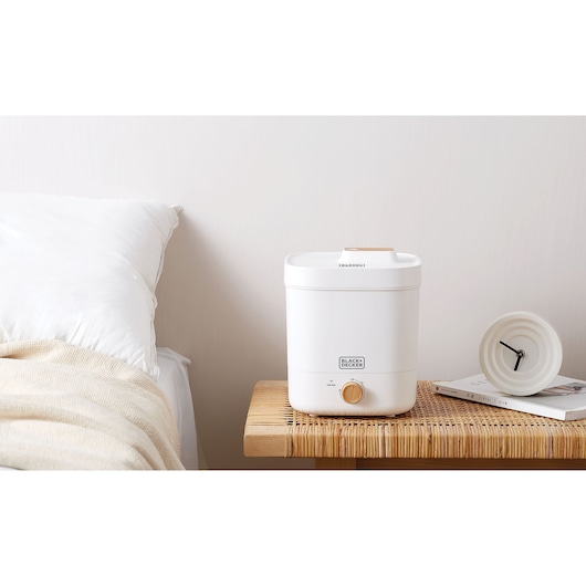 Photo of BLACK+DECKER HM4125 compact white kitchen appliance with gold knob on bedside table next to clock.