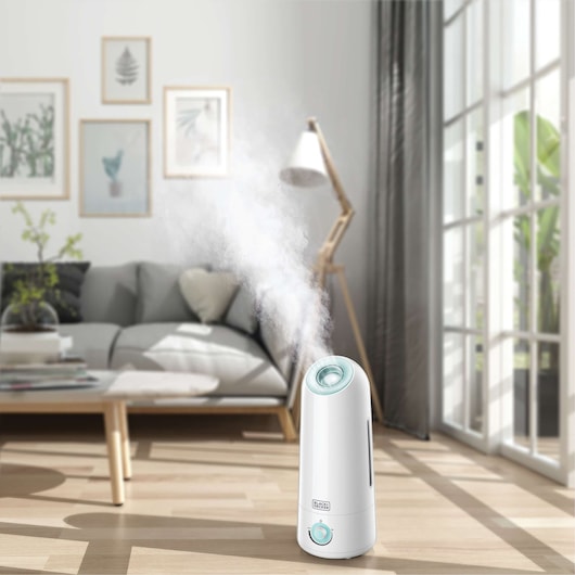 BLACKDECKER HM5000 humidifier emitting mist in a bright modern living room.