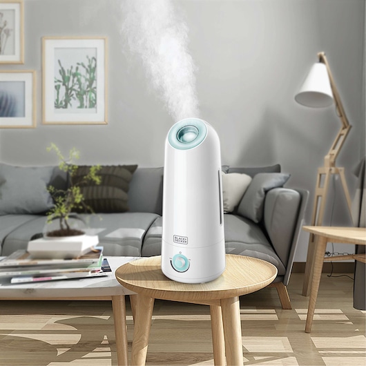 BLACKDECKER HM5000 white humidifier with blue accents on round table in modern living room.