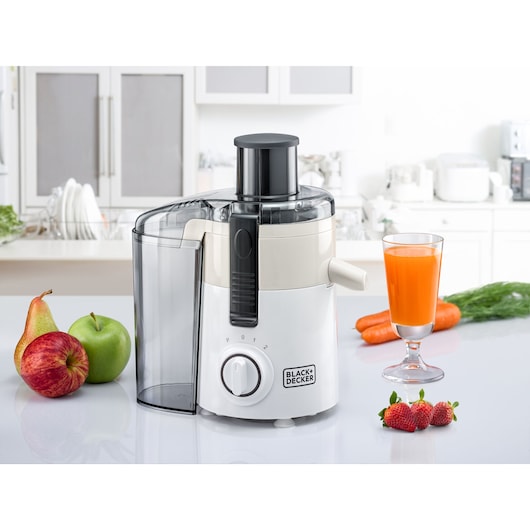 BLACKDECKER JE250 juicer on kitchen counter with fruits, carrots, strawberries, and a glass of orange juice.
