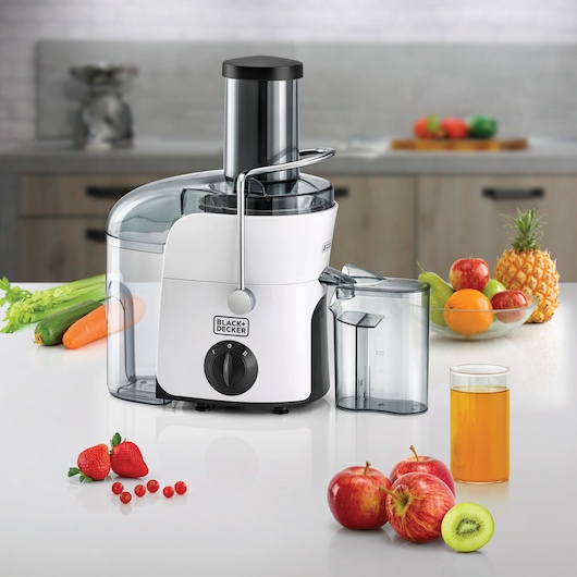 BLACK+DECKER JE780 juicer on kitchen counter with assorted fruits, vegetables, juice glass, and bowl of fruit.