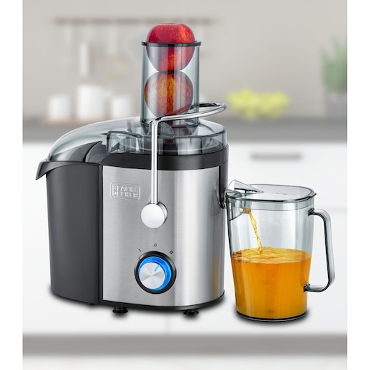 BLACKDECKER JE800 stainless steel juicer front view with apples in feed chute and juice pouring into clear pitcher.