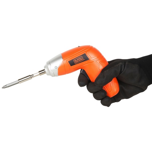 Photo of BLACKDECKER KC3610 orange cordless screwdriver held in a gloved hand, side view on white background.