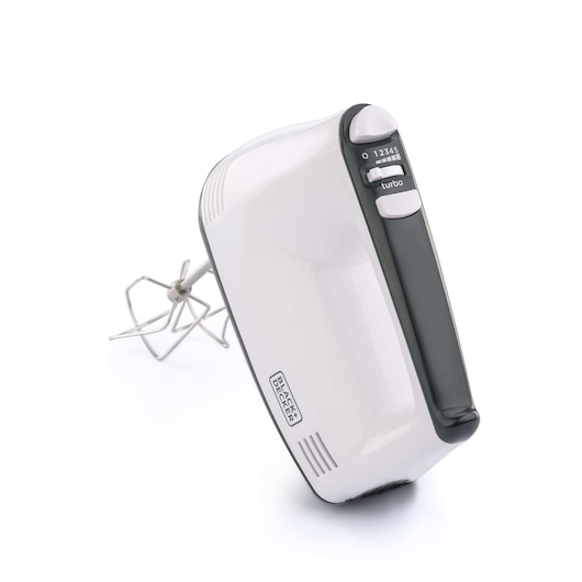 A BLACK+DECKER hand mixer with a white body and black handle, featuring several speed settings and a turbo button. One metal beater attachment is visible beside the mixer.