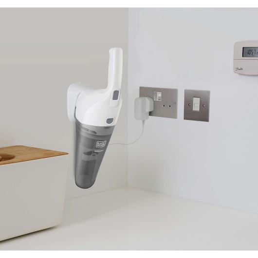BLACK+DECKER handheld vacuum NVB215WN mounted on wall charging in a kitchen corner.