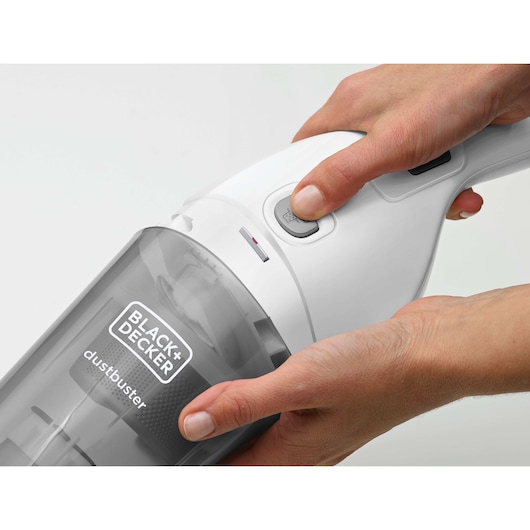 Close-up of BLACK+DECKER NVB215WN handheld vacuum cleaner, white and grey, being switched on.