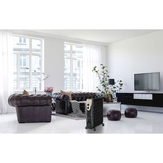 BLACKDECKER OR011FD radiator heater in modern living room with leather sofas and large windows.