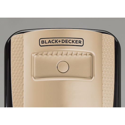 Photo of BLACK+DECKER OR070D appliance top view showing gold surface with center button and embossed grip pattern.