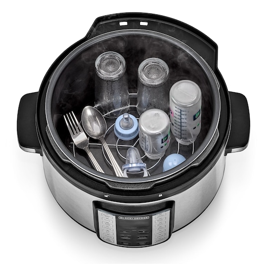 BLACKDECKER PCP1010 electric pressure cooker top view with baby bottles, utensils, and accessories inside for sterilization.