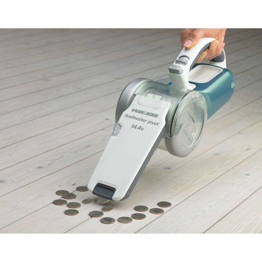 Photo of BLACK+DECKER PV1425N handheld vacuum cleaner picking up coins on light wood floor.