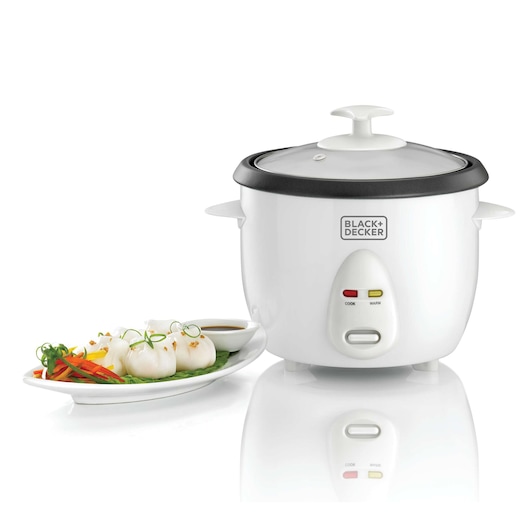 A BLACK+DECKER rice cooker with a glass lid is shown next to a white plate of food, including steamed dumplings and colorful vegetables with a dipping sauce.