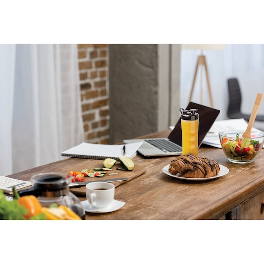 BLACKDECKER SBX300BCG blender bottle with orange juice on kitchen table with salad, pastry, coffee, and laptop.